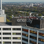 Der Schriftzug von enercity am Ihmezentrum im Vordergrund, die drei warmen Brüder im Hintergrund.